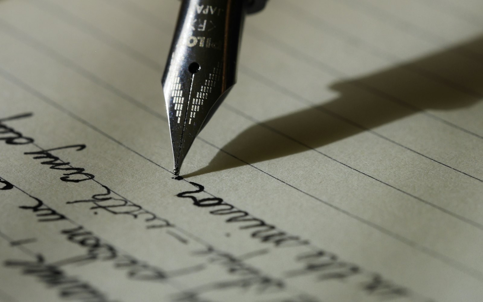 A fountain pen resting on a handwritten page