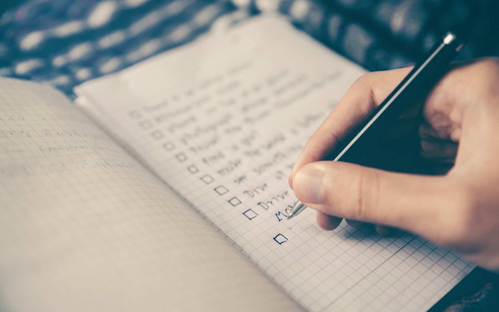 A hand writing a schedule into a planner