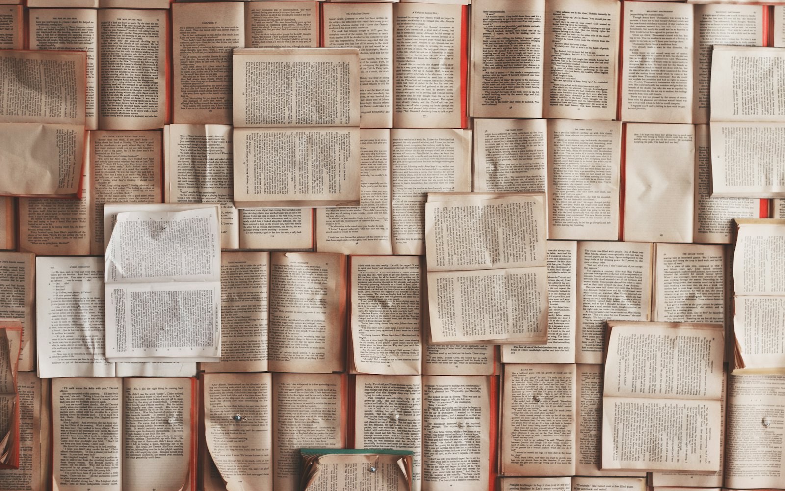 Several open books spread across a desk at once