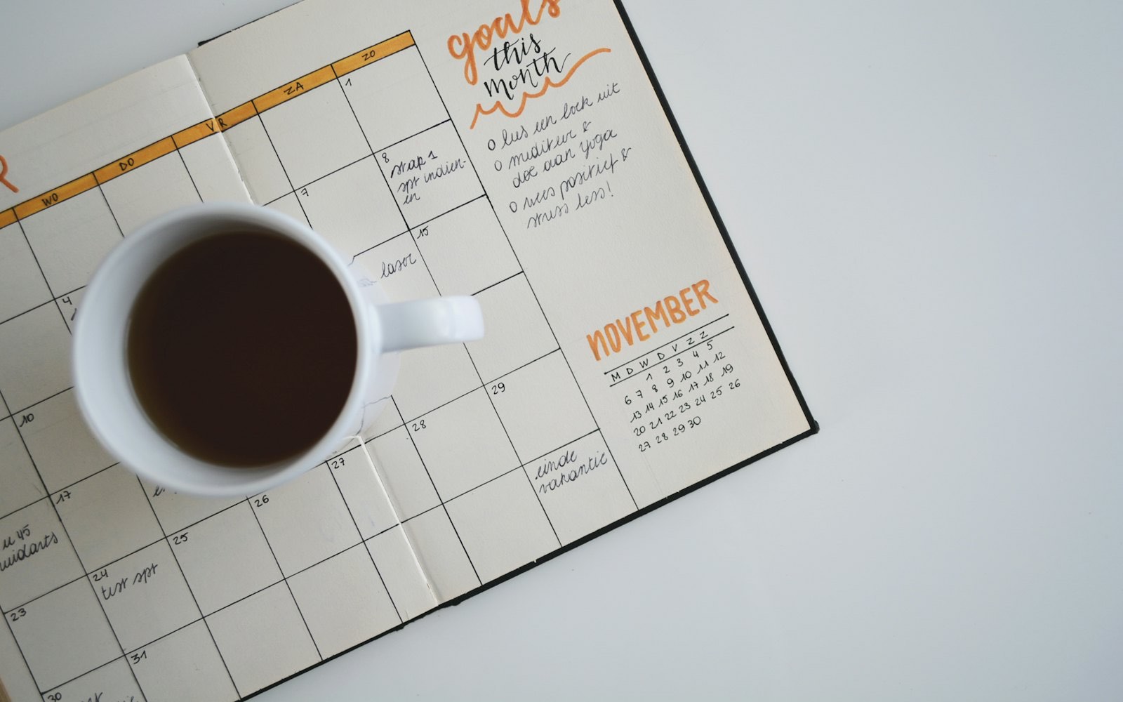 A planner and a cup of coffee photographed from above